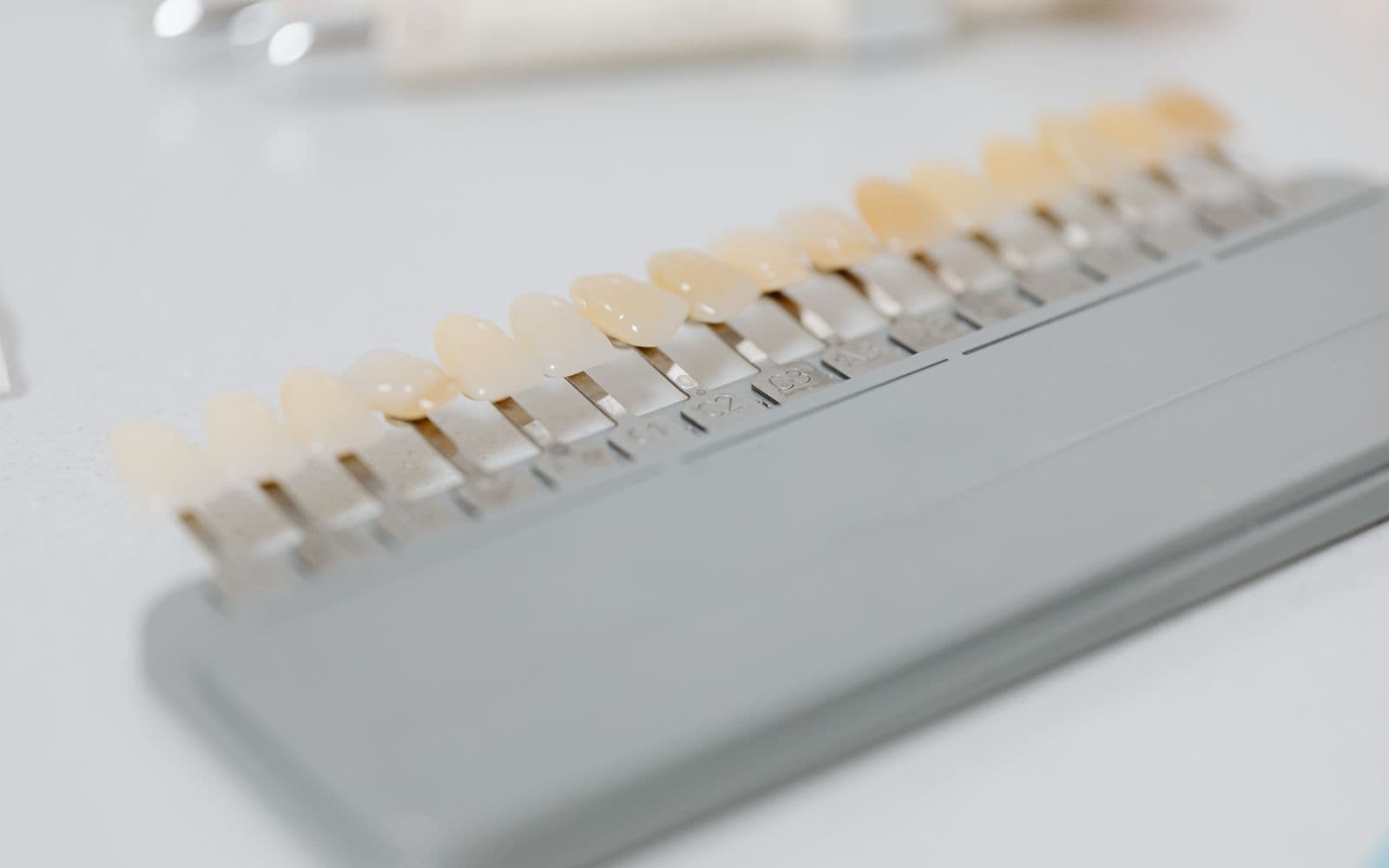 Shade-guide check at Smiles by Goh — matching whitening to your natural teeth