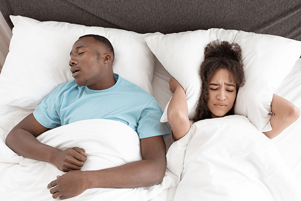 a couple in bed trying to sleep